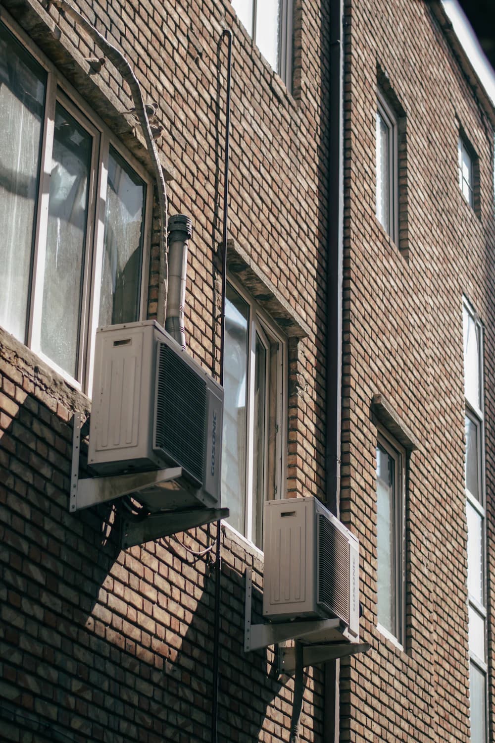 Buitenunits van een airco-installatie tegen de gevel van een woning