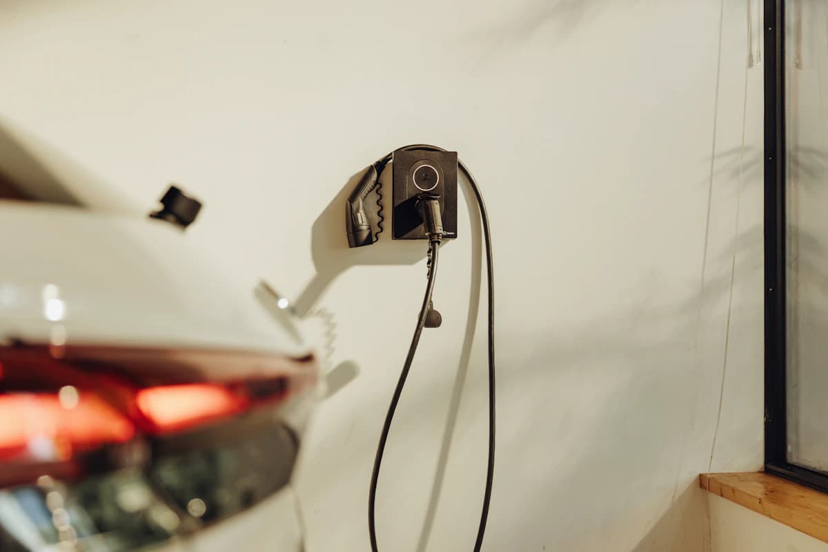 Wandlaadpunt aan een muur, met de laadkabel aangesloten op een wagen